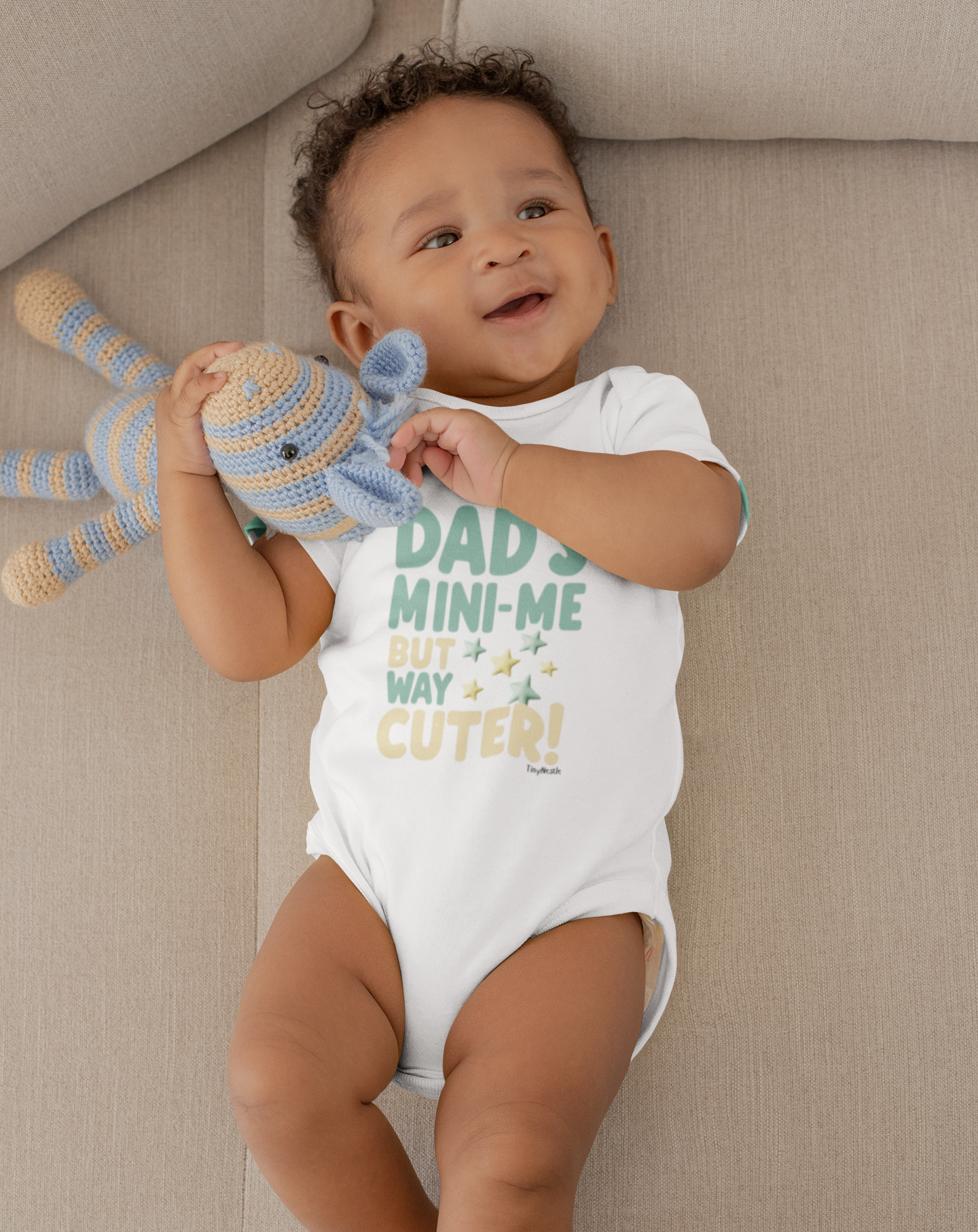 baby laying down and  wearing a Dad's Mini Me But Way Cuter design on Short Sleeve Bodysuit